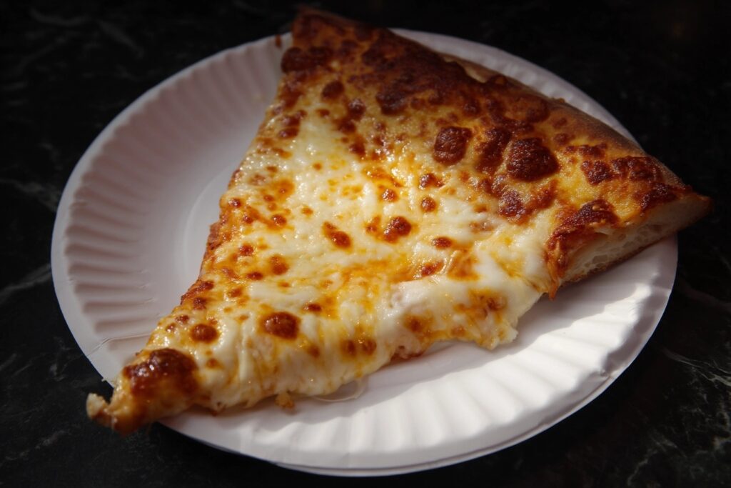 Best pizza in Fort Collins - Krazy Karl's Pizza slice with gooey cheese pull on paper plat