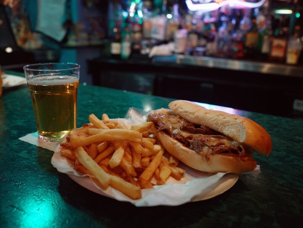 steak sandwich on a paper plate with fries - Best Dive Bar Dinners in Pueblo